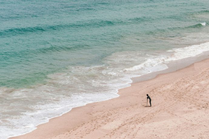 Playa de Cádiz con palmeras y arena dorada, espacio amplio para deportes y familias